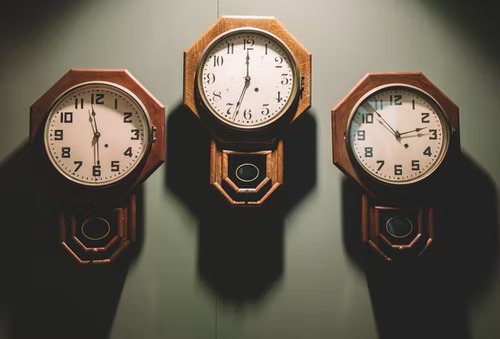 Three wall clocks showing different times showing how to figure out the best times to post on TikTok.
