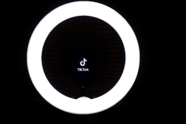 Icône TikTok au milieu d'une lumière circulaire.