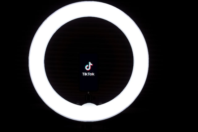 Ícone do TikTok no meio de um anel luminoso.