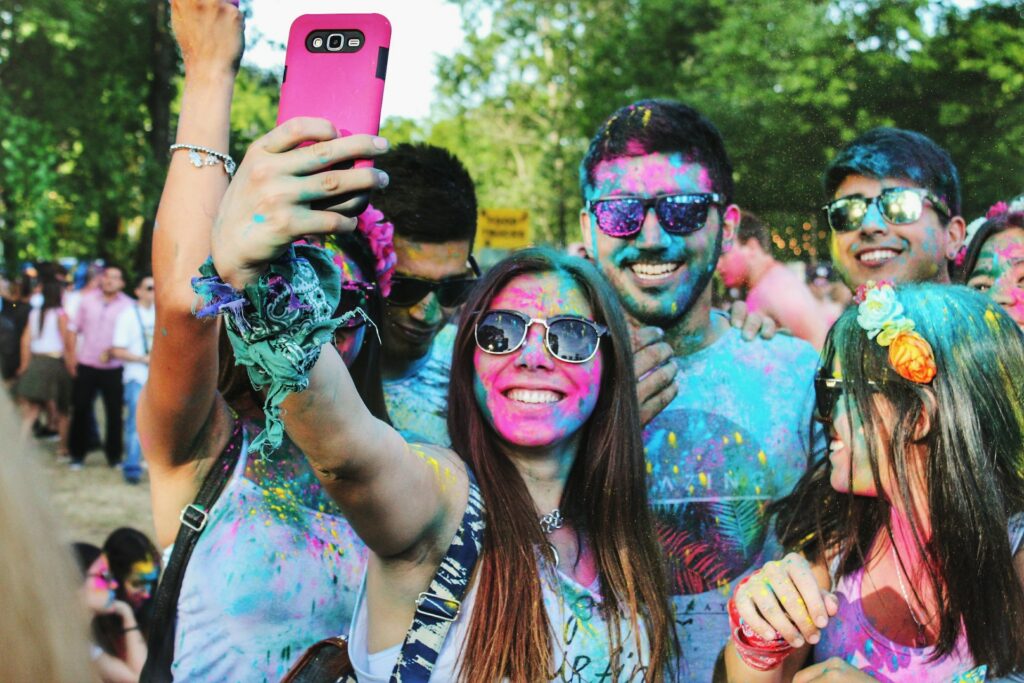 Un groupe d'amis couverts de peinture colorée se filme pour TikTok. 