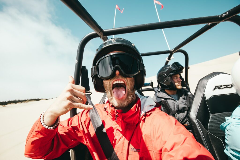 Een man in een ATV steekt zijn tong uit naar de camera. 