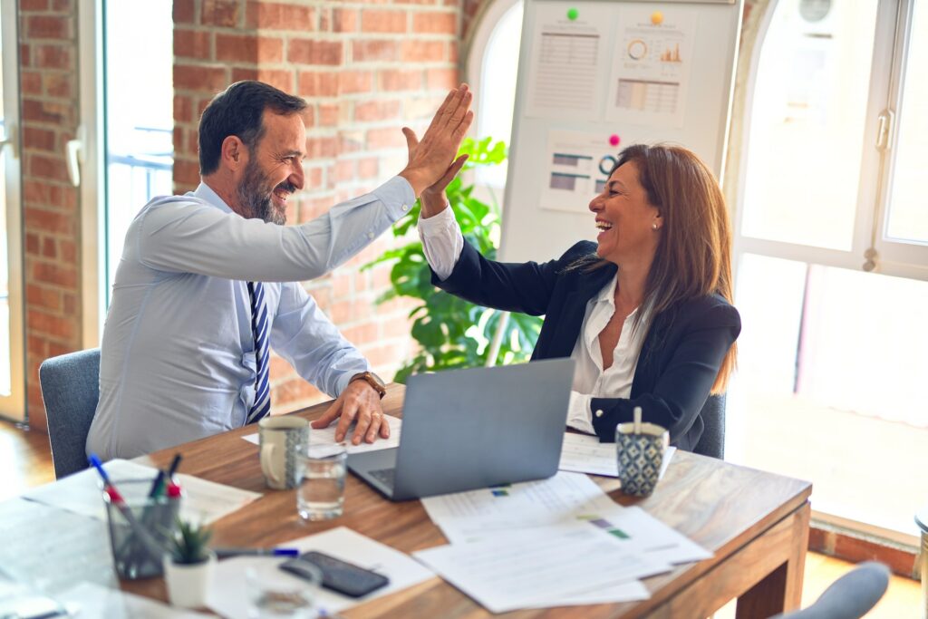 Two TikTok agency professionals giving each other a high five. 