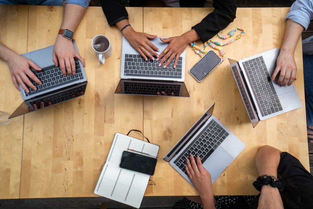 Un grup de oameni care lucrează la laptopuri. 