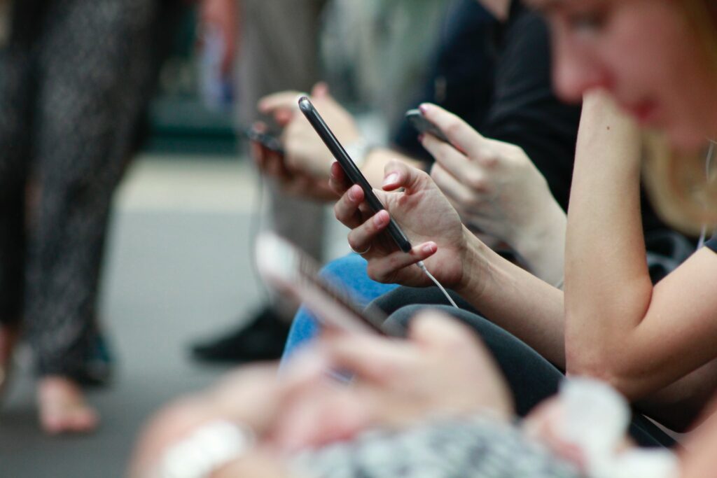 Pessoas assistindo a vídeos do TikTok em seus smartphones. 