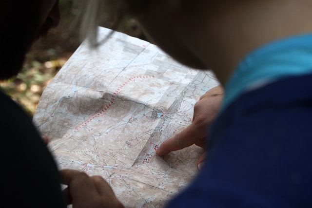 Person pointing at a location on a map.