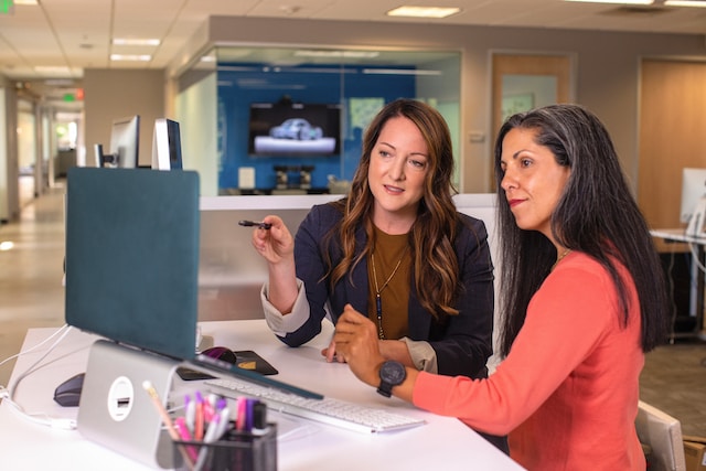 Duas mulheres estão em uma reunião de negócios. 