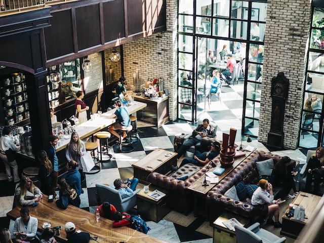 Mensen kijken video's op hun telefoon in een koffiebar. 