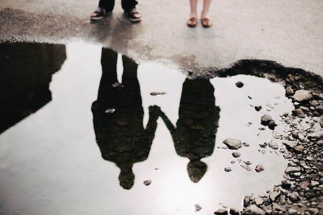 O reflexo de um casal na água. 