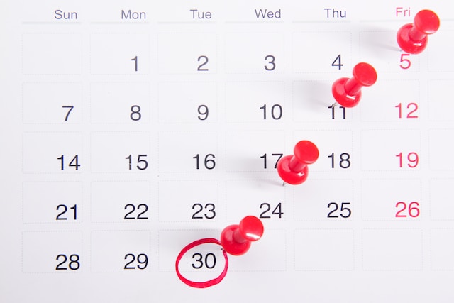 Een kalender met rode punaises. 