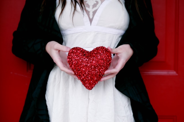 Una mujer con una almohada de corazones brillantes. 