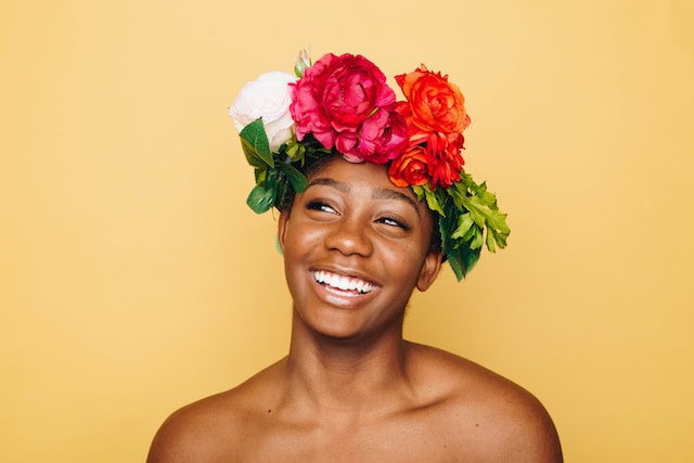 A laughing woman wearing a crown of followers.