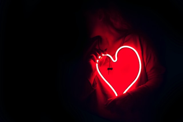 A woman holding a heart-shaped lamp. 