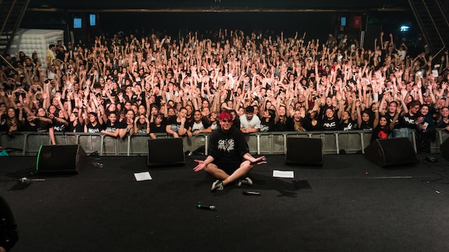 Uma grande multidão em frente a um palco. 