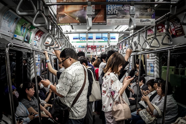 Pessoas em um trem assistindo a vídeos em seus smartphones. 