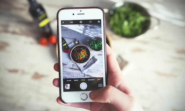 用手机给食物拍照的人。