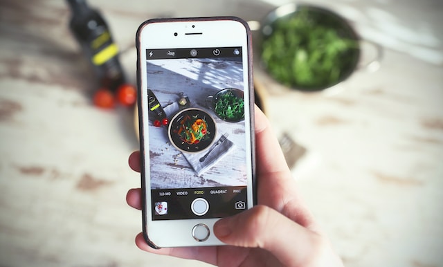 Una persona che fotografa il proprio cibo con il telefono.