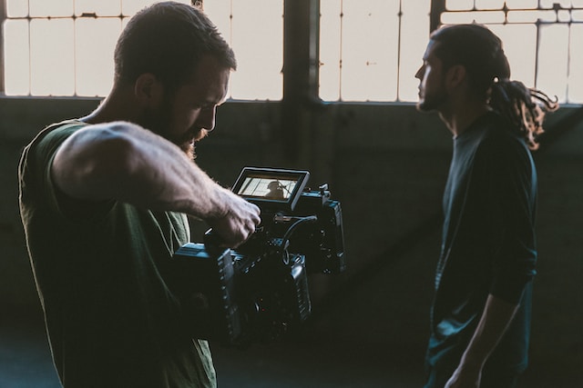 Un hombre graba una película con una videocámara. 