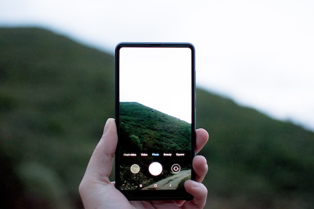 Una persona haciendo una foto con su teléfono en modo retrato. 