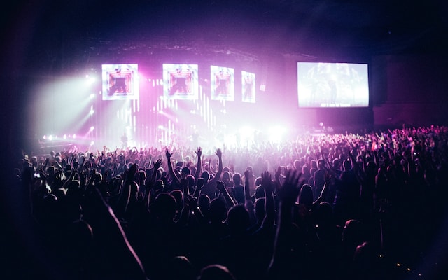 A stadium full of happy fans watching a live performance.