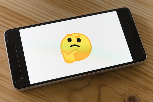Phone screen displaying a thinking emoji. 