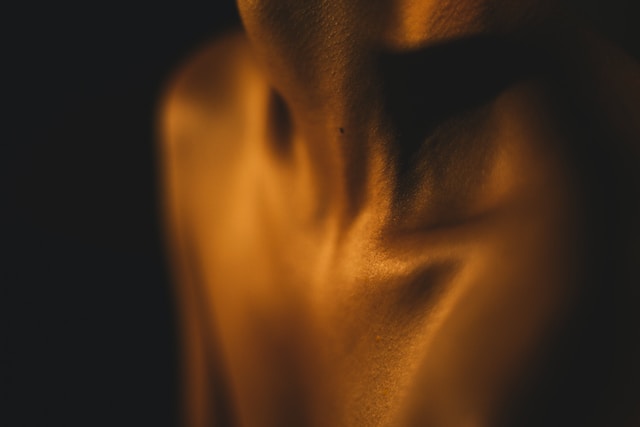 Foto ravvicinata che mostra le spalle nude e la clavicola di una donna. 