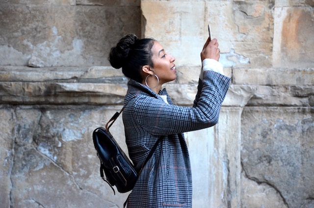 Uma mulher gravando um vídeo usando seu telefone. 