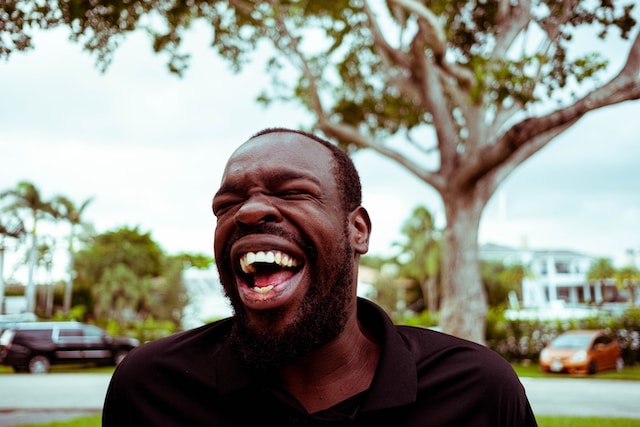 A man standing outside and laughing. 