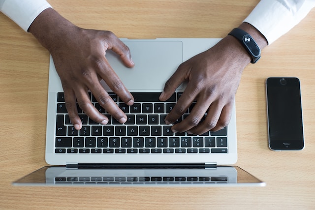 A person typing on a laptop keyboard. 