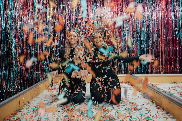 Twee vrouwen genieten van confetti. 