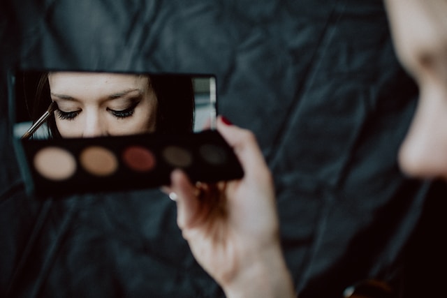 Een vrouw brengt oogmake-up aan voor een instructievideo. 