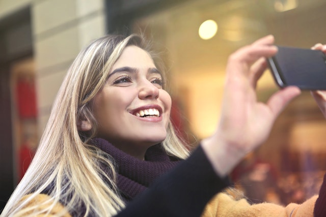 A lady shares her excitement as she takes a picture of herself.