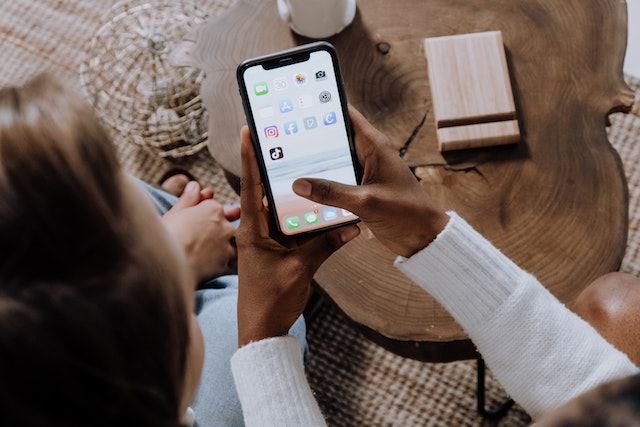 Uma senhora com sua amiga que deseja abrir o aplicativo TikTok em seu smartphone. 