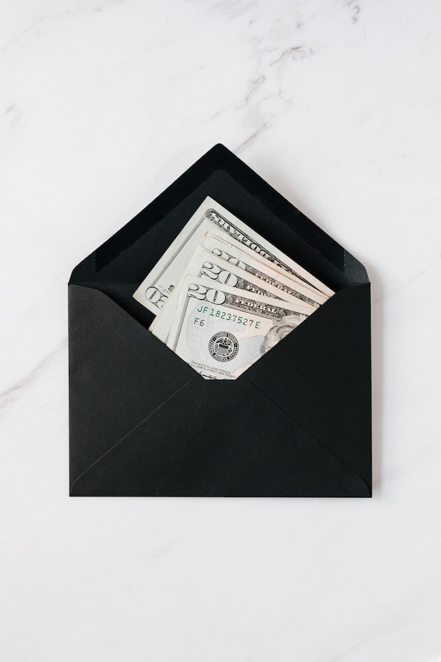 Paper bills inside of a black envelope.