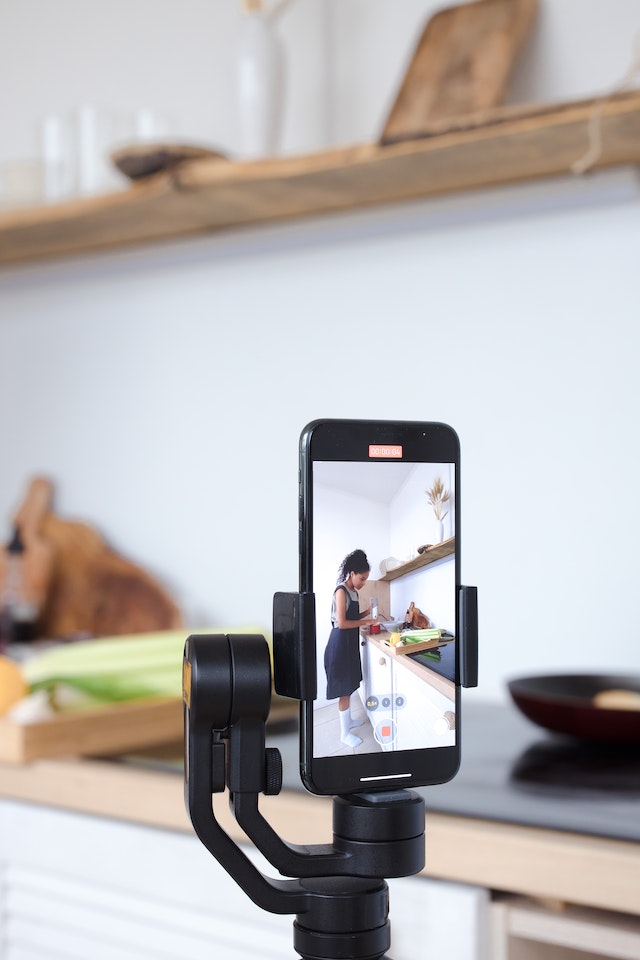 A woman recording herself cooking for a TikTok video.