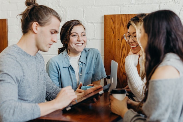 Un grupo de jóvenes profesionales celebran una reunión informal tomando un café. 