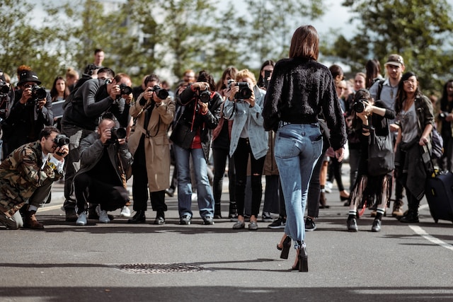 Un grup de fotografi fotografiază o femeie. 