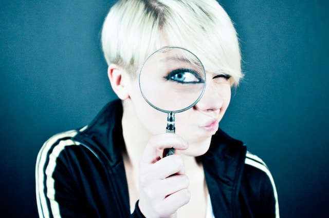 A woman with a magnifying glass.