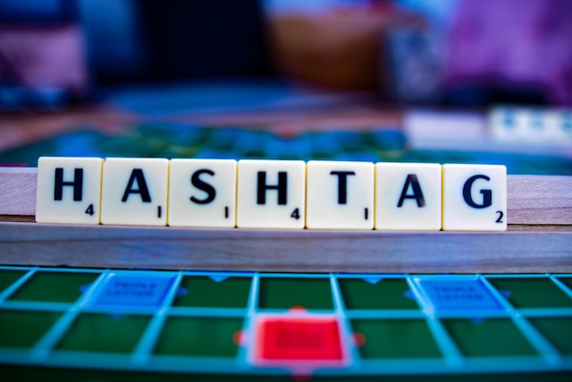 Peças de Scrabble que soletram a palavra "Hashtag".