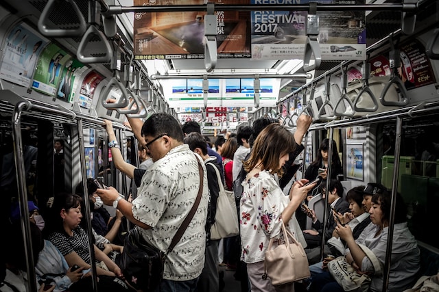Menschen in einem Zug, die sich Videos auf ihren Handys ansehen. 