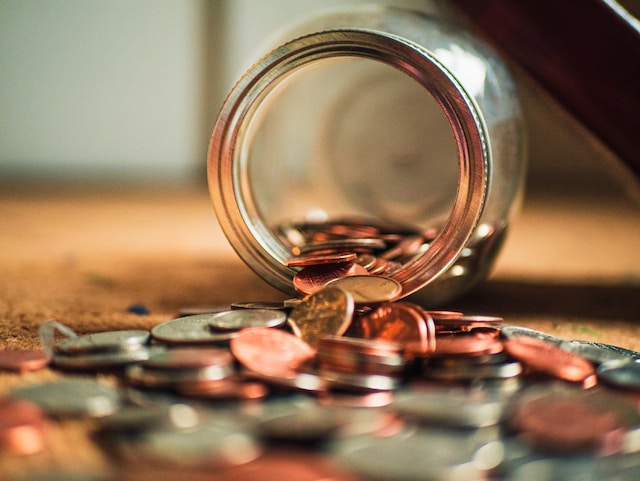 Coins spilling out of a jar. 