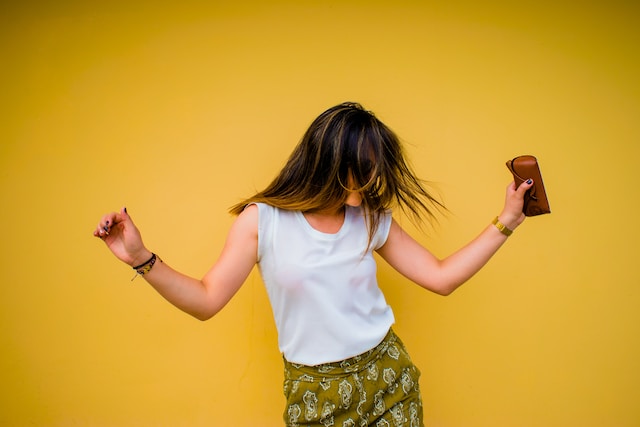 財布を持って踊る女性がTikTokコンテンツを作成。