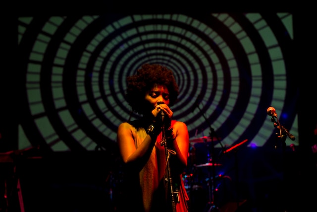 Una mujer cantando en el escenario. 