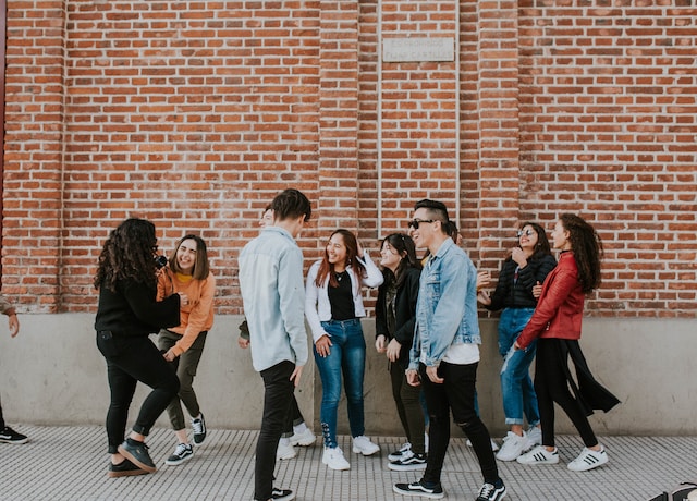 A group of people hanging out outside a building.