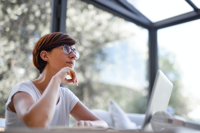 Een vrouw die in haar kantoor zit na te denken over hoe ze haar TikTok Influencer Marketing campagne kan laten werken.