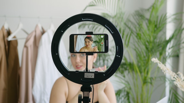 A woman recording herself via a smartphone.