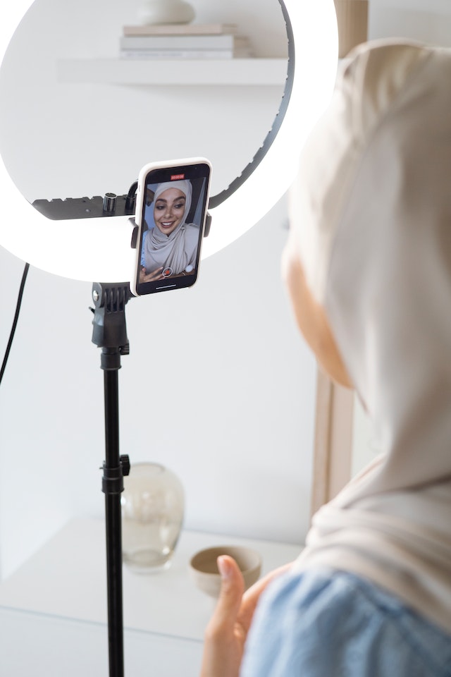 A girl recording a TikTok video with a ring light.