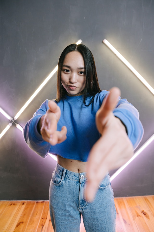 A girl pointing at the screen and recording a video for TikTok. 