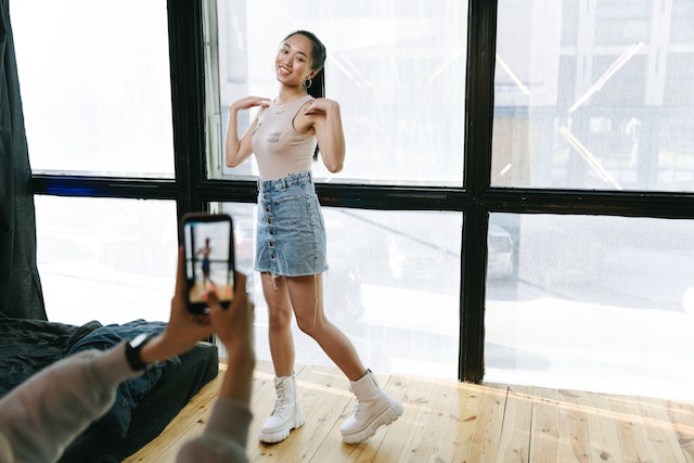 A close view of a person recording a young lady dancing.