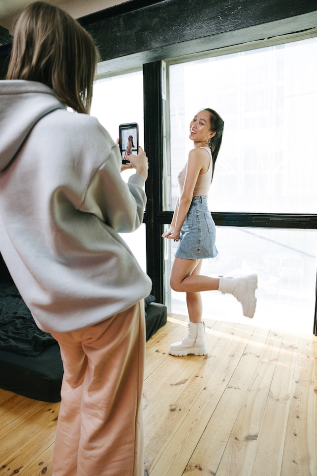 Una chica de pie grabando un vídeo para TikTok.