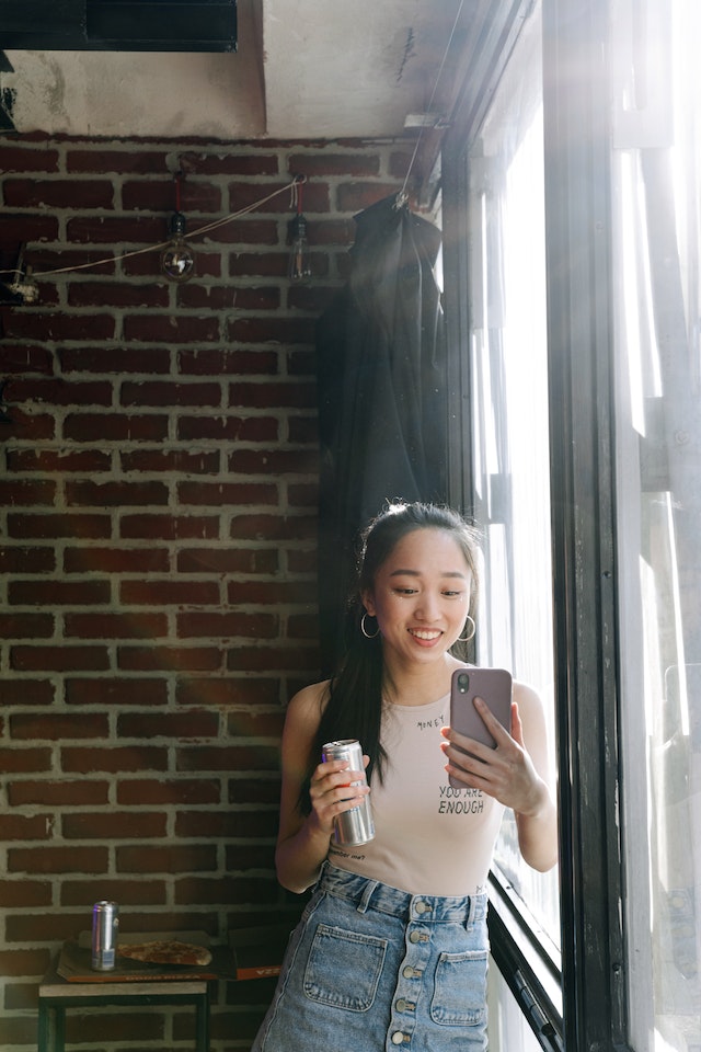 A girl holding a smartphone and recording a TikTok video.